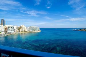a view of the ocean from a balcony at Spinola Bay top floor seafront 3 bedroom Apartment with panoramic sea views - by Getawaysmalta in St. Julianʼs