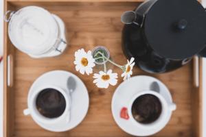 two cups of coffee on a wooden tray with flowers at Casa Fola - City Centre Rooms in Verona