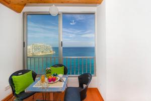 a dining room with a view of the ocean at Spinola Bay top floor seafront 3 bedroom Apartment with panoramic sea views - by Getawaysmalta in St. Julianʼs