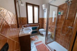 a bathroom with a shower and a sink and a toilet at Casa Diana P3115 in Riola Sardo +30 photos