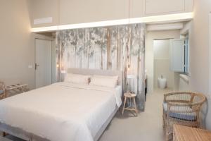 una camera con un letto bianco e un murale di Casale Tre Gelsi a Cingoli