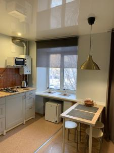 イヴァノヴォにあるДвухкомнатная квартира-студияの窓、テーブル付きのキッチンが備わります。