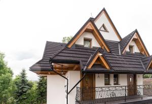 a house with a black roof at Rusińska Osada in Bukowina Tatrzańska