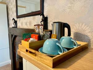 a wooden tray with two teapots on a counter at Harts Head Hotel in Settle