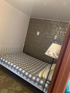 イヴァノヴォにあるДвухкомнатная квартира-студияのランプ付きの部屋の小さなベッド1台
