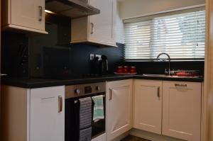 a kitchen with white cabinets and a black counter top at Benson House Box in Box