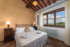 a bedroom with a bed and a large window at Agriturismo Podere Sertofano in Barberino di Val dʼElsa