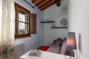 uma sala de estar com um sofá e uma janela em Agriturismo Podere Sertofano em Barberino di Val dʼElsa