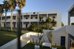 an exterior view of a building with palm trees at Estalagem Da Ponta Do Sol in Ponta do Sol