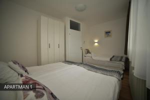 a bedroom with two beds in it with a closet at Apartman Slatki dom 1 in Sarajevo
