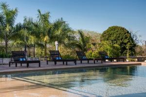 un grupo de sillas sentadas junto a una piscina en Hacienda Yabucu, en Seyé