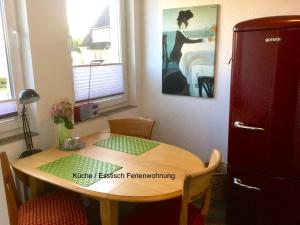 a kitchen with a wooden table and a bedroom at Ferienhaus Us lütt Hus und das Zimmer Linde im Haupthaus in Oldenburg