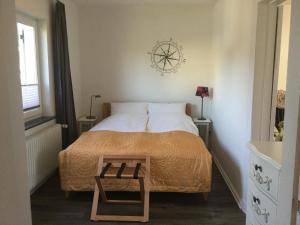 1 dormitorio con 1 cama con reloj en la pared en Ferienhaus Us lütt Hus und das Zimmer Linde im Haupthaus en Oldenburg