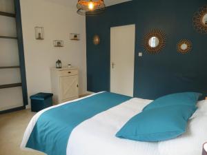 - une chambre avec un grand lit et un mur bleu dans l'établissement L'étape Normande, à Fécamp