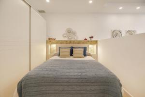 1 dormitorio con 1 cama grande con almohadas azules en Apartamento Naypa with free parking, en Cádiz