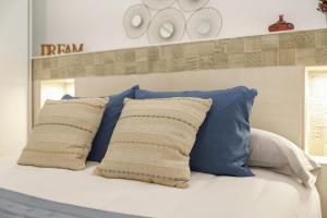 ein Bett mit blauen und weißen Kissen darauf in der Unterkunft Apartamento Naypa with free parking in Cádiz