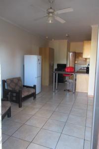 a living room with a refrigerator and a table at Pab-Love Guest House in Kuruman
