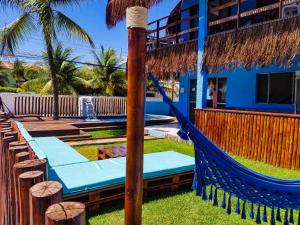 una hamaca frente a un edificio con un complejo turístico en Pousada Casa Nui - Porto de Galinhas by Concavus, en Porto de Galinhas