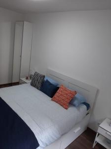 un letto con cuscini sopra in una camera da letto di Rozsa55 apartment 2 rooms a Budapest