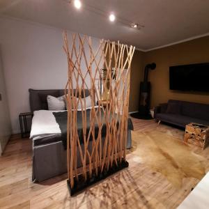 a living room with a bed and wooden sticks at business-lodging Apartmenthaus in Höhr-Grenzhausen