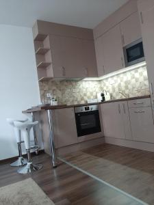 een keuken met witte kasten en een tafel en stoelen bij Rozsa55 apartment 2 rooms in Boedapest
