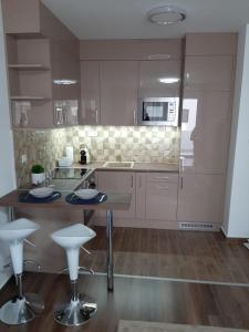 ブダペストにあるRozsa55 apartment 2 roomsのテーブルとスツール付きのキッチンが備わります。