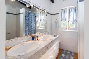 een badkamer met 2 wastafels en een grote spiegel bij VILLA EN CAP EN FONT in Cap d'en Font