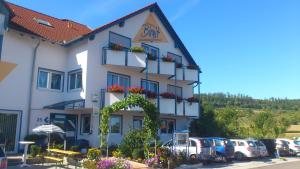 ein großes Gebäude mit Blumen davor in der Unterkunft Hotelpension Gästehaus Birgit in Bad Mergentheim