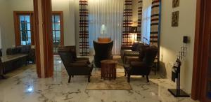 a living room with couches chairs and a table at Silver Palm Hotel in Arusha