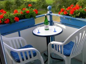 einen Tisch mit 2 Stühlen und eine Flasche Wein auf dem Balkon in der Unterkunft Hotelpension Gästehaus Birgit in Bad Mergentheim