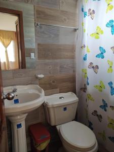 a bathroom with a toilet and a sink at Hostal El Eden de Mindo in Mindo