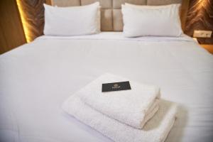 una pila de toallas sentadas en una cama en EDEM Hotel en Türkistan