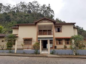 une maison avec une montagne en arrière-plan dans l'établissement Pousada Il Conventino, à Santa Teresa