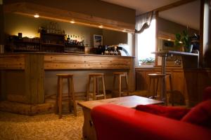 een bar in een kamer met krukken en een bar bij Les Arobiers in Lamoura