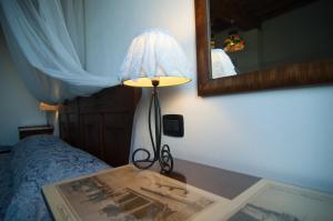 a lamp sitting on a table next to a bed at Arpaderba B&B in Livorno