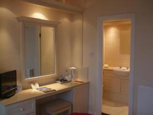 a bathroom with a sink and a mirror at The Chatsworth in Weymouth