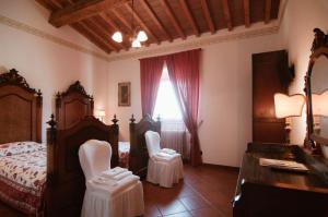 a bedroom with a bed and two chairs in it at Arpaderba B&B in Livorno