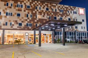 a building with a parking lot in front of it at ibis Caucaia Porto do Pecem in Caucaia