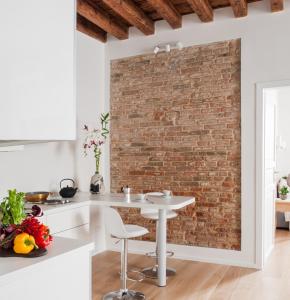 un muro di mattoni in una cucina con tavolo e sedie di Ca del Mar Venice Luxury Apartments a Venezia