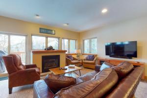 a living room with a leather couch and a fireplace at Beautiful East Vail 3 Bedroom Condo w/Hot Tub On shuttle Route. in Vail