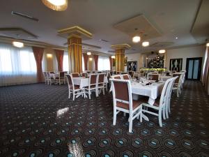 uma sala de jantar com mesas e cadeiras brancas em Amso Residence em Sibiu