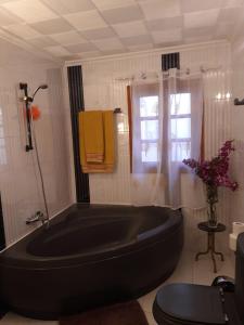 een groot zwart bad in een badkamer met een raam bij Los Molinos in Valles de Ortega