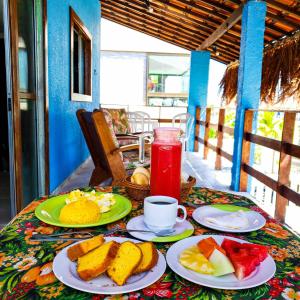 - une table avec des assiettes de nourriture et une boisson dans l'établissement Casa Nui - Porto de Galinhas, à Porto de Galinhas