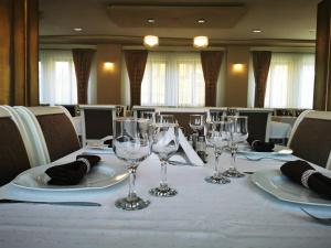 シビウにあるAmso Residenceの白いテーブルクロスにワイングラスをかけたテーブル