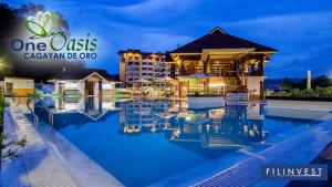 a view of a hotel with a pool at night at One Oasis By Paseo de Corazon Residence in Cagayan de Oro