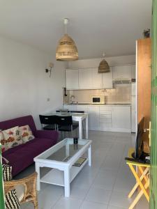 a living room with a purple couch and a kitchen at El bañadero in El Cotillo