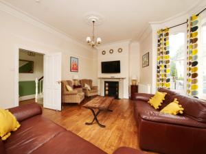 Holiday Homes in York في يورك: غرفة معيشة مع أثاث من الجلد ومدفأة