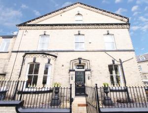 una vieja casa de ladrillo con una valla negra en Holiday Homes in York, en York