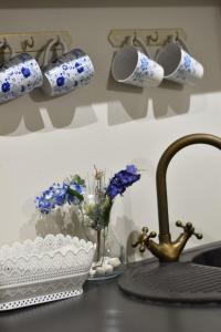 eine Küchentheke mit einem Waschbecken und blauen und weißen Tassen in der Unterkunft Paju Apartement with Sauna in Võru