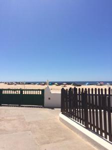 a black fence with the ocean in the background at El bañadero in El Cotillo